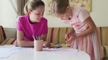 Bir anne ve kızı evde birlikte boyama faaliyetlerinde bulunuyorlar.