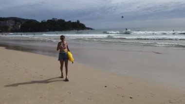 Genç bir kadın kumsalda güzel bir günün tadını çıkarıyor. 