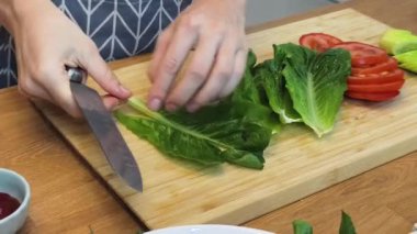 Taze sebzelerden ve çeşitli malzemelerden oluşan lezzetli bir salata pişiren bir şef. 