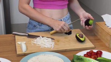 Çağdaş mutfakta Chiken Shawarma 'yı hazırlayan genç bir kadın.