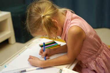 Genç bir anne ev ödevleriyle kızına destek olur.