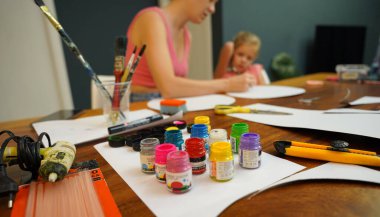 Bir anne ve küçük kızı, yaratıcılığı teşvik eden renkli bir resim faaliyetinde bulunuyorlar.