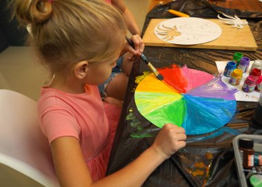 Bir anne ve küçük kızı, yaratıcılığı teşvik eden renkli bir resim faaliyetinde bulunuyorlar.