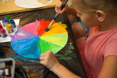 Bir anne ve küçük kızı, yaratıcılığı teşvik eden renkli bir resim faaliyetinde bulunuyorlar.