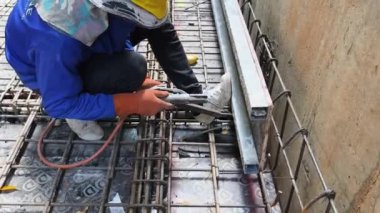 İşçiler inşaat alanındaki beton yapıların istikrarı için gerekli çelik parmaklıkları güçlendiriyorlar.