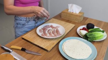 Çağdaş mutfakta Chiken Shawarma 'yı hazırlayan genç bir kadın.