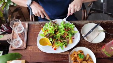 Bir adam modern bir kafe ortamında keyifli bir yemek ve içecekten zevk alıyor.