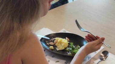 Bir kadın, modern bir kafe ortamında hoş bir yemek ve içecekten zevk alıyor.