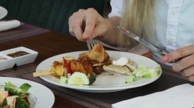 Bir kadın, modern bir kafe ortamında hoş bir yemeğin tadını çıkarıyor.