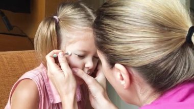 Neşeli bir anne ve kız birlikte tırnak sanatı yapıyor. 