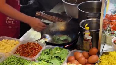 Usta bir aşçı dışarıda Tayland mutfağını tutkuyla pişiriyor.. 