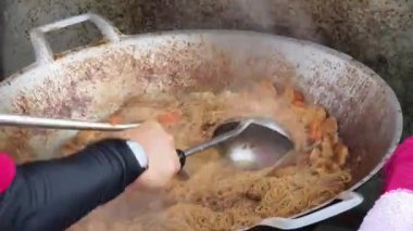 Usta bir aşçı dışarıda Tayland mutfağını tutkuyla pişiriyor.. 