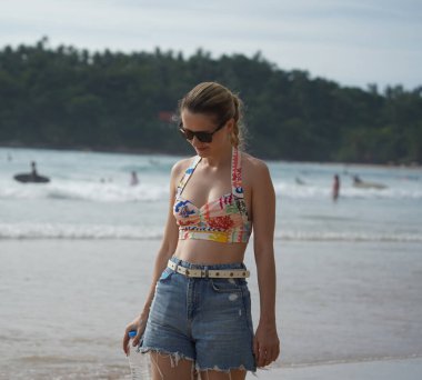 Genç bir kadın kumsalda güzel bir günün tadını çıkarıyor. 