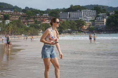 Genç bir kadın kumsalda güzel bir günün tadını çıkarıyor. 