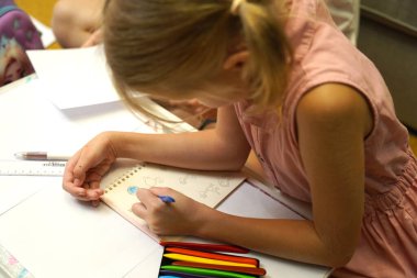 Genç bir anne ev ödevleriyle kızına destek olur.