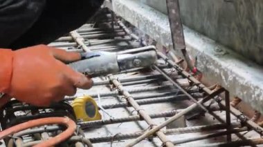İşçiler inşaat alanındaki beton yapıların istikrarı için gerekli çelik parmaklıkları güçlendiriyorlar.