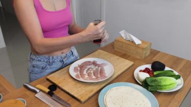 Çağdaş mutfakta Chiken Shawarma 'yı hazırlayan genç bir kadın.