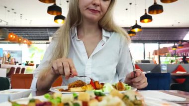 Bir kadın, modern bir kafe ortamında hoş bir yemeğin tadını çıkarıyor.