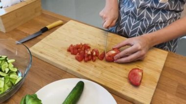 Taze sebzelerden ve çeşitli malzemelerden oluşan lezzetli bir salata pişiren bir şef. 