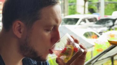 Bir adam modern bir kafe ortamında keyifli bir yemek ve içecekten zevk alıyor.