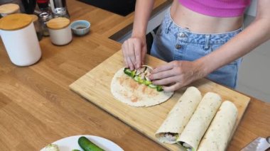 Çağdaş mutfakta Chiken Shawarma 'yı hazırlayan genç bir kadın.