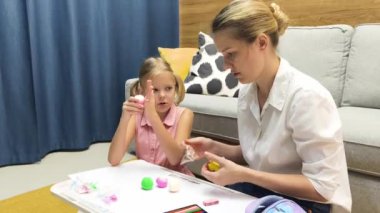 Genç bir anne ev ödevleriyle kızına destek olur.