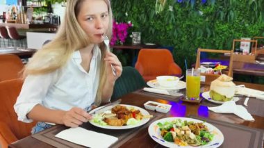 Bir kadın, modern bir kafe ortamında hoş bir yemeğin tadını çıkarıyor.