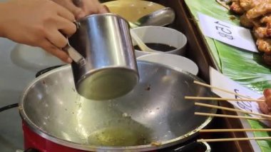 Usta bir aşçı dışarıda Tayland mutfağını tutkuyla pişiriyor.. 