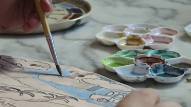 Genç bir anne ve kızı evde sanatsal bir seansın keyfini çıkarıyorlar. Renkli sanatlarıyla meşgul ve bağ kuruyorlar.