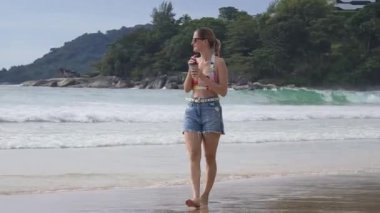 Genç bir kadın kumsalda güzel bir günün tadını çıkarıyor. 