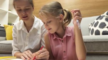 Genç bir anne ev ödevleriyle kızına destek olur.