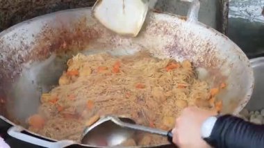 Usta bir aşçı dışarıda Tayland mutfağını tutkuyla pişiriyor.. 