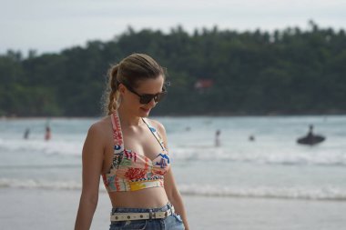 Genç bir kadın kumsalda güzel bir günün tadını çıkarıyor. 