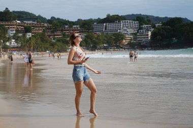 Genç bir kadın kumsalda güzel bir günün tadını çıkarıyor. 