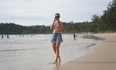 Genç bir kadın kumsalda güzel bir günün tadını çıkarıyor. 