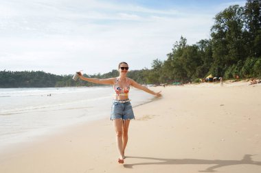 Genç bir kadın kumsalda güzel bir günün tadını çıkarıyor. 