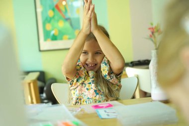 Sanat öğretmeni atölyede iki kıza termo mozaik montajı öğretiyor. 