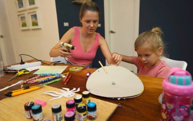 Bir anne ve küçük kızı, yaratıcılığı teşvik eden renkli bir resim faaliyetinde bulunuyorlar.