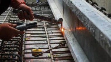 İşçiler inşaat alanındaki beton yapıların istikrarı için gerekli çelik parmaklıkları güçlendiriyorlar.