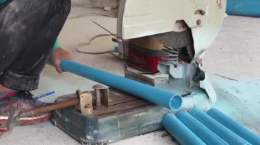Büyük bir beton parçası kesmek için dairesel testere kullanan bir inşaatçı..