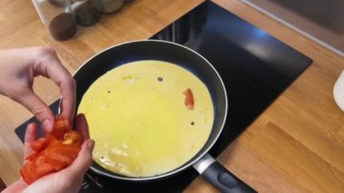 Bir kadın güzel tasarlanmış modern mutfakta ustalıkla lezzetli bir yumurta hazırlıyor.