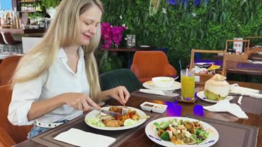 Bir kadın, modern bir kafe ortamında hoş bir yemeğin tadını çıkarıyor.