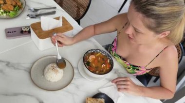 Bir kadın, modern bir kafe ortamında hoş bir yemek ve içecekten zevk alıyor.