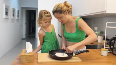 Bir anne ve kız, bu aktiviteyi keşfederken güvenli bir şekilde paten kaymaya hazırdır.