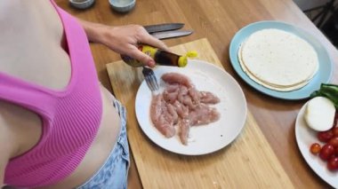 Çağdaş mutfakta Chiken Shawarma 'yı hazırlayan genç bir kadın.