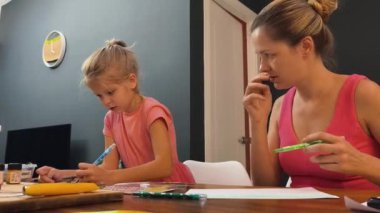 Bir anne ve küçük kızı, yaratıcılığı teşvik eden renkli bir resim faaliyetinde bulunuyorlar.