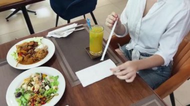 Bir kadın, modern bir kafe ortamında hoş bir yemeğin tadını çıkarıyor.