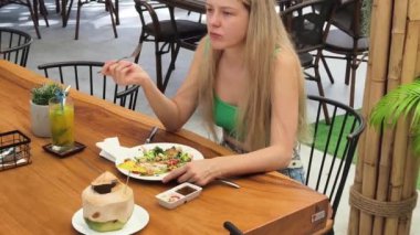 Bir kadın, modern bir kafe ortamında hoş bir yemeğin tadını çıkarıyor.