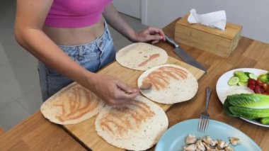 Çağdaş mutfakta Chiken Shawarma 'yı hazırlayan genç bir kadın.