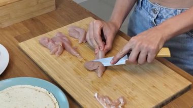 Çağdaş mutfakta Chiken Shawarma 'yı hazırlayan genç bir kadın.